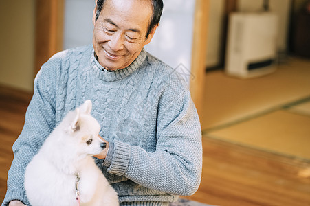 抱着博美犬的老人图片