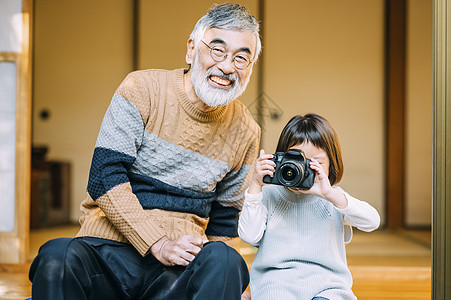 孙女用相机给爷爷拍照图片