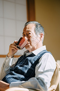 坐在椅子上喝咖啡的老人图片