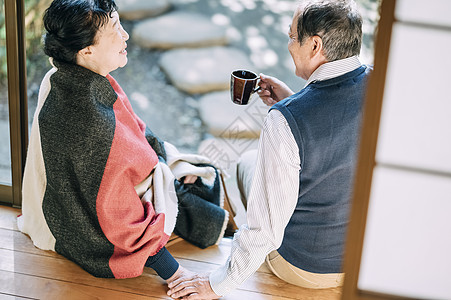 坐在院子里喝咖啡休息的老年夫妇图片