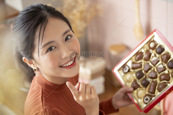 拿着一盒巧克力开心的年轻女子图片