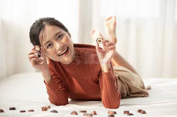 拿着巧克力开心的年轻女子图片