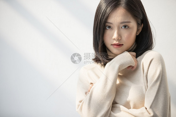 编辑放松的圆翻领放松与阳光的年轻女子的画像图片