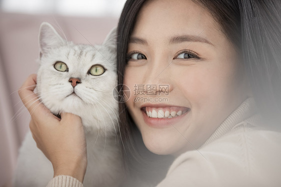 年轻女子亲昵的抱着宠物猫咪图片