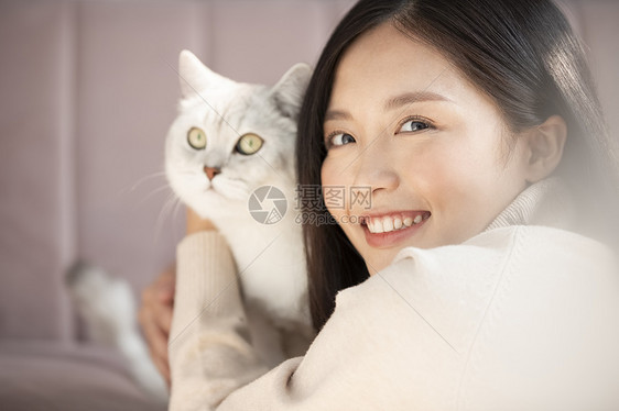 年轻女子亲昵的抱着宠物猫咪图片