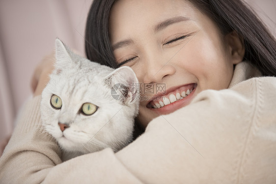 抱着宠物猫咪开心的年轻女子图片