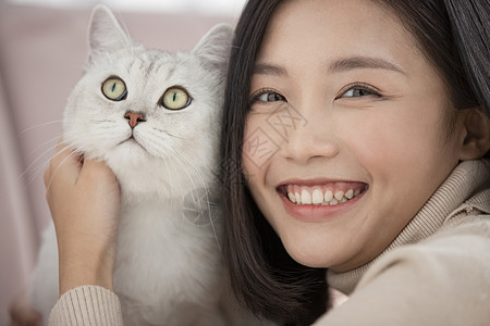 抱着宠物猫咪开心的年轻女子图片