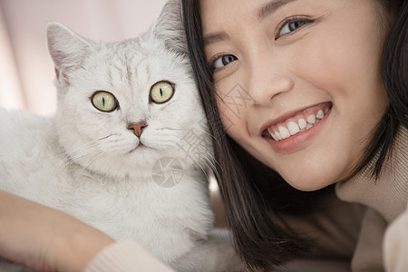 抱着宠物猫咪开心的年轻女子图片