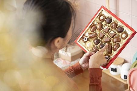亚洲人生活白人年轻女子选择巧克力图片