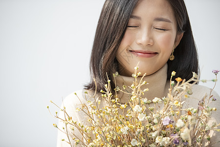 美容年轻女遵守手捧花的年轻女子的画像图片