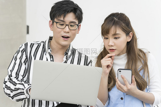 白人年轻女智能手机年轻的男人和女人在户外看电脑图片