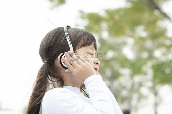 户外戴着耳机听音乐的小女孩图片