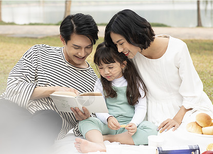 父母陪伴孩子在户外阅读图片素材