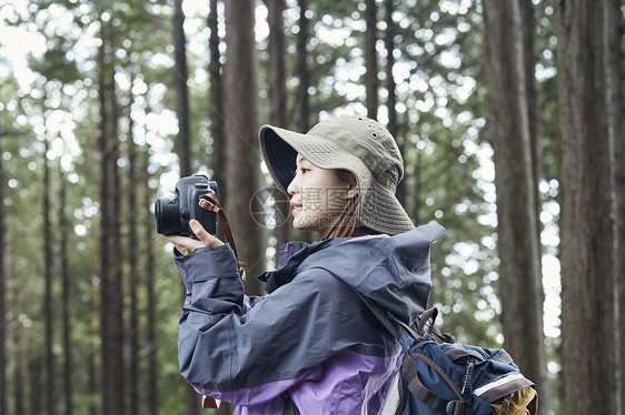 年轻女人徒步登山探险拍照图片