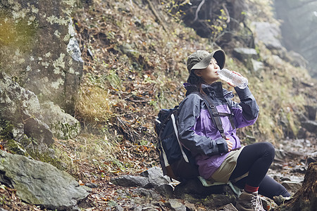 年轻女人徒步登山休息喝水图片