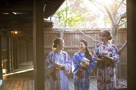 安慰天笑脸妇女和朋友享受温泉之旅图片