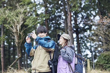 两个年轻人徒步登山拍照图片