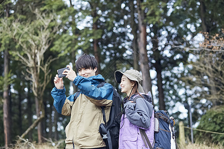 年轻情侣户外徒步爬山拍照图片