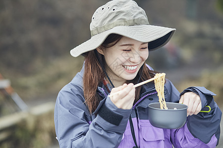 年轻美女户外露营吃饭图片