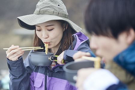 年轻情侣户外露营用餐图片