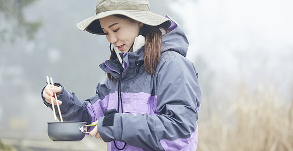 年轻女人徒步登山探险吃东西图片