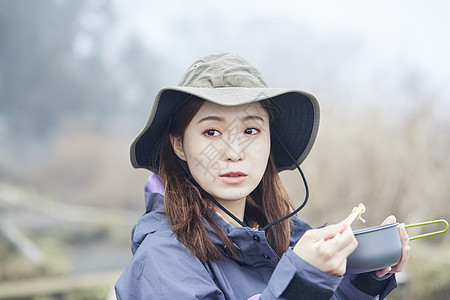 年轻女人徒步登山探险吃东西图片