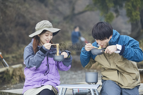 两个年轻人徒步登山休息吃面图片