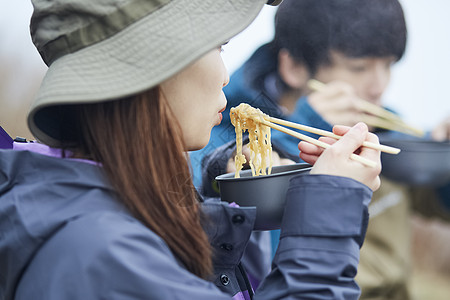 两个年轻人徒步登山休息吃面图片