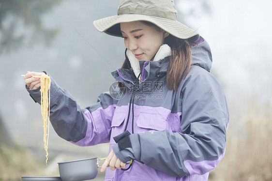 年轻女人徒步登山休息吃面图片