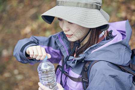 森林里徒步休息喝水的青年女性图片