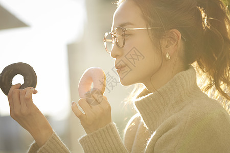 拿着甜甜圈的青年女子图片