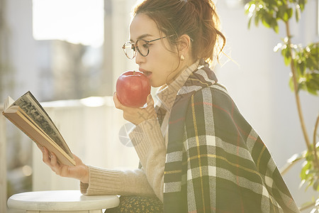 马秋吃苹果看书的青年女子背景