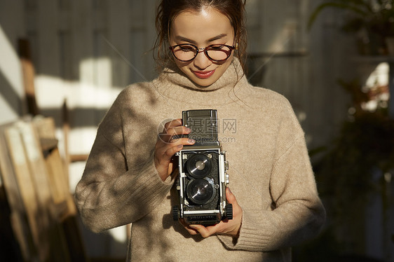 拿着相机的年轻女子图片