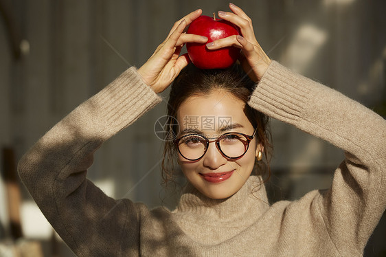 举着苹果的青年女子图片