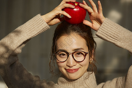 头顶苹果可爱的年轻女子图片