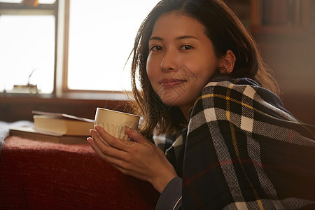 卧室里捧着咖啡的青年女性图片