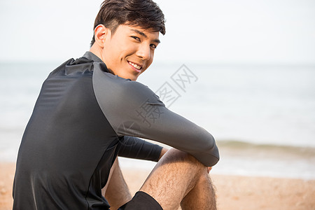 坐在海滩上休息的成年男子图片