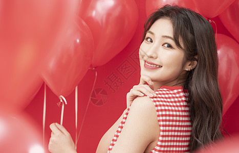 年轻女子拿着红色气球图片