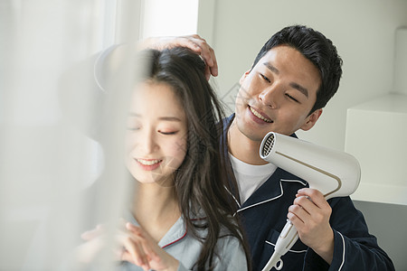 丈夫给妻子吹头发图片素材