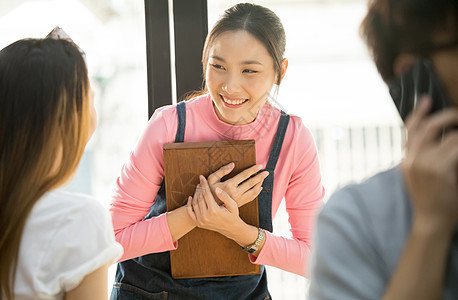 咖啡馆女职员拿着托盘接待顾客图片