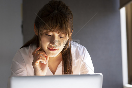 孤独的日本人办公楼观看个人计算机的妇女图片