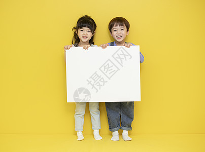 两个小孩举着画纸背景图片