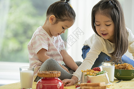 坐在桌子上吃东西的小女孩图片