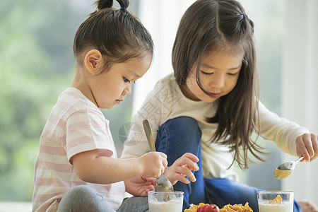 坐在桌子上吃东西的小女孩图片