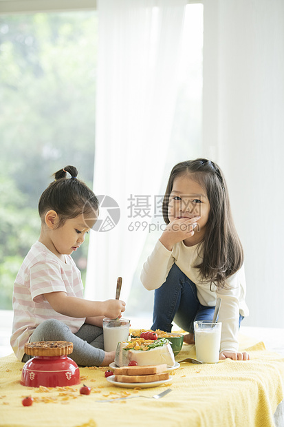 坐在餐桌上吃东西的小女孩图片