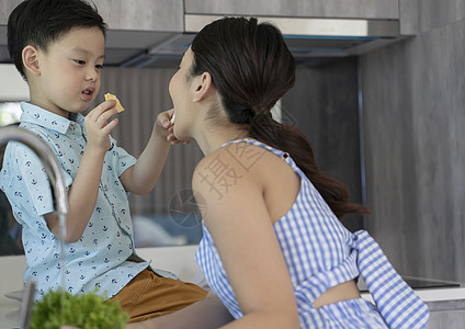 喂妈妈吃零食的小男孩图片