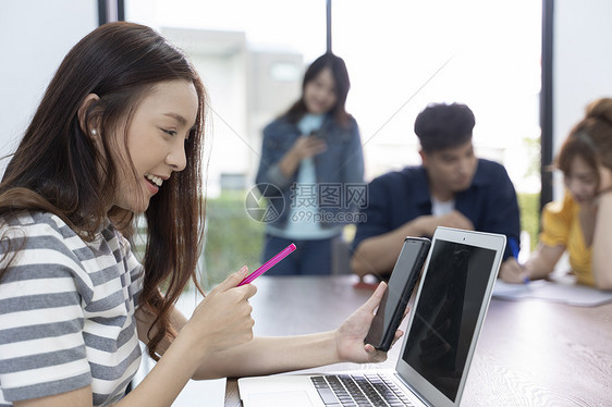 拿着手机视频通话的年轻女子图片