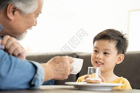 祖父拿着咖啡与孙子干杯图片