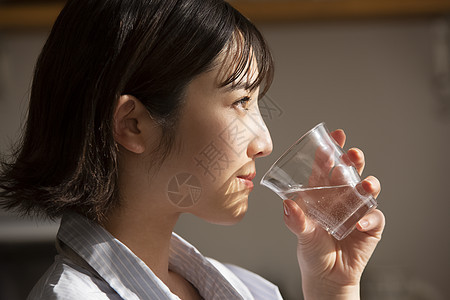 拿着水杯喝水的青年女子图片