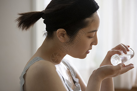 使用化妆水护肤的年轻女子图片